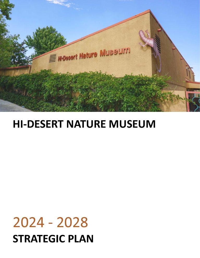 Hi-Desert Nature Museum 2024-2028 Strategic Plan - a brown building with a metal lizard sculpture on the corner and green bushes along the bottom